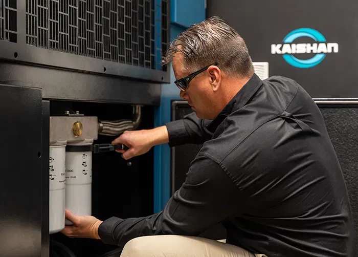 Technician performing maintenance on a Kaishan compressor